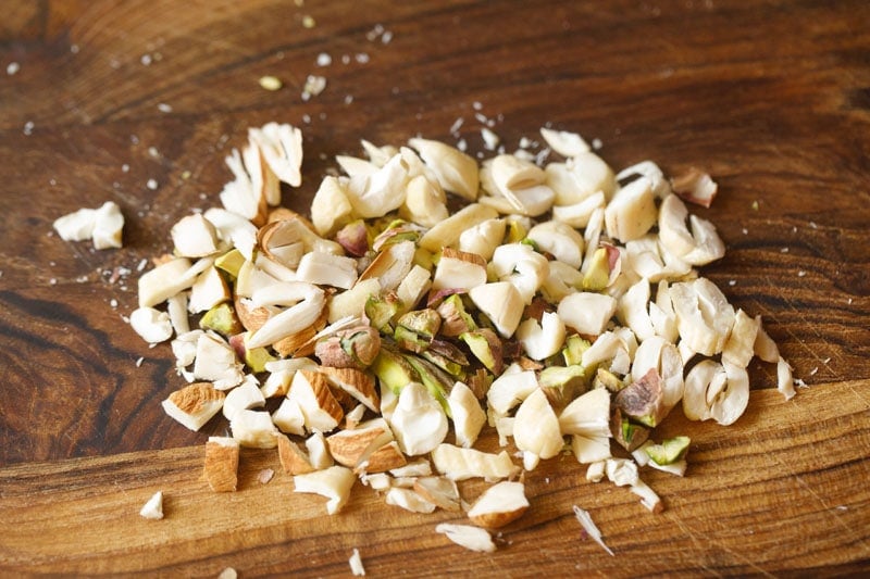 chopped trio of nuts on a wooden cutting board