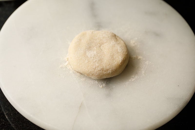 dough ball flattened with some flour sprinkled