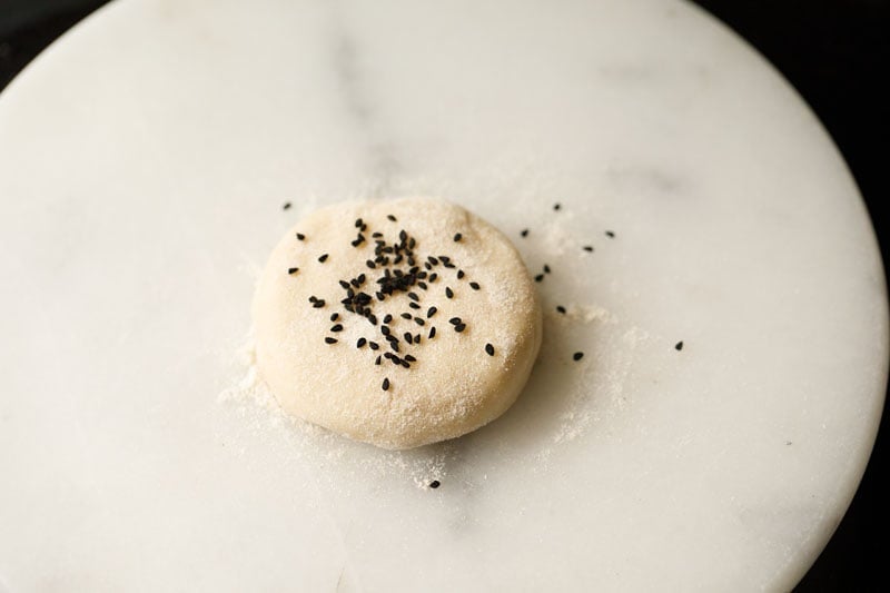 nigella seeds sprinkled on flattened dough ball