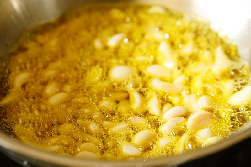 garlic cloves frying in mustard oil
