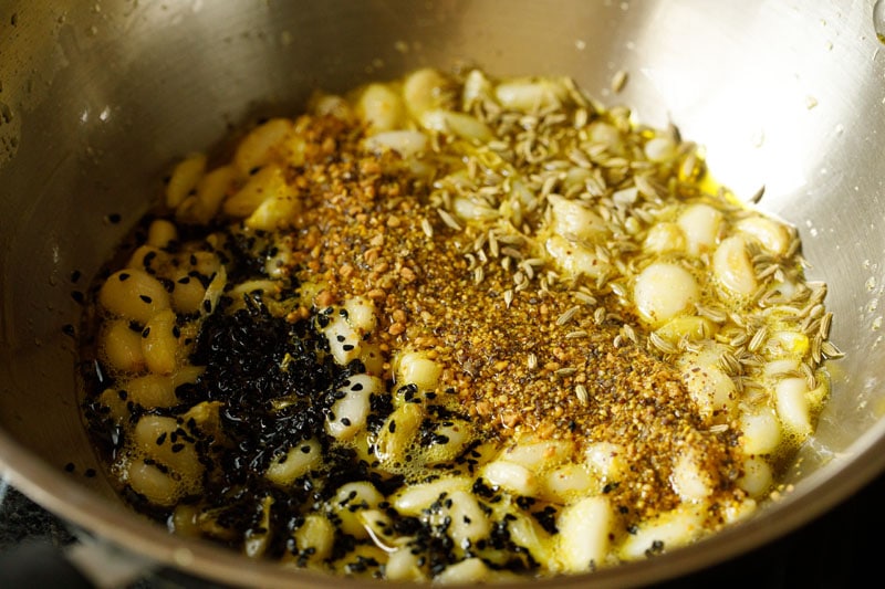 ground spices, fennel and nigella seeds added to garlic oil mix
