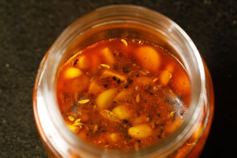 overhead shot of garlic in a jar that has been topped off with additional mustard oil