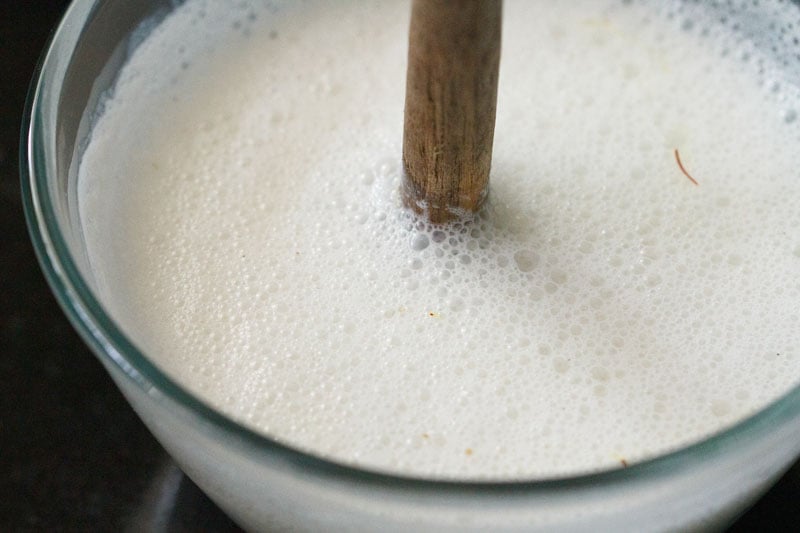 cardamom powder and saffron strand mixed with wooden churner