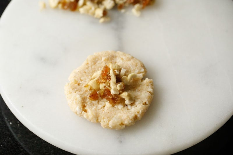 kofta ball flattened with some portion of cashew and raisins in center