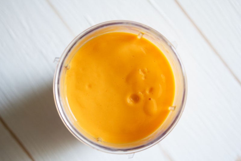 overhead shot of blended mango milkshake in the blender