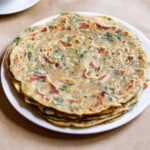a stack of methi paratha in a white plate