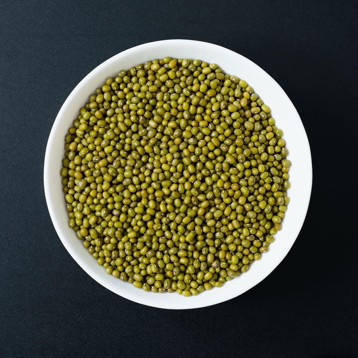 mung beans or green gram in a white bowl or a black table