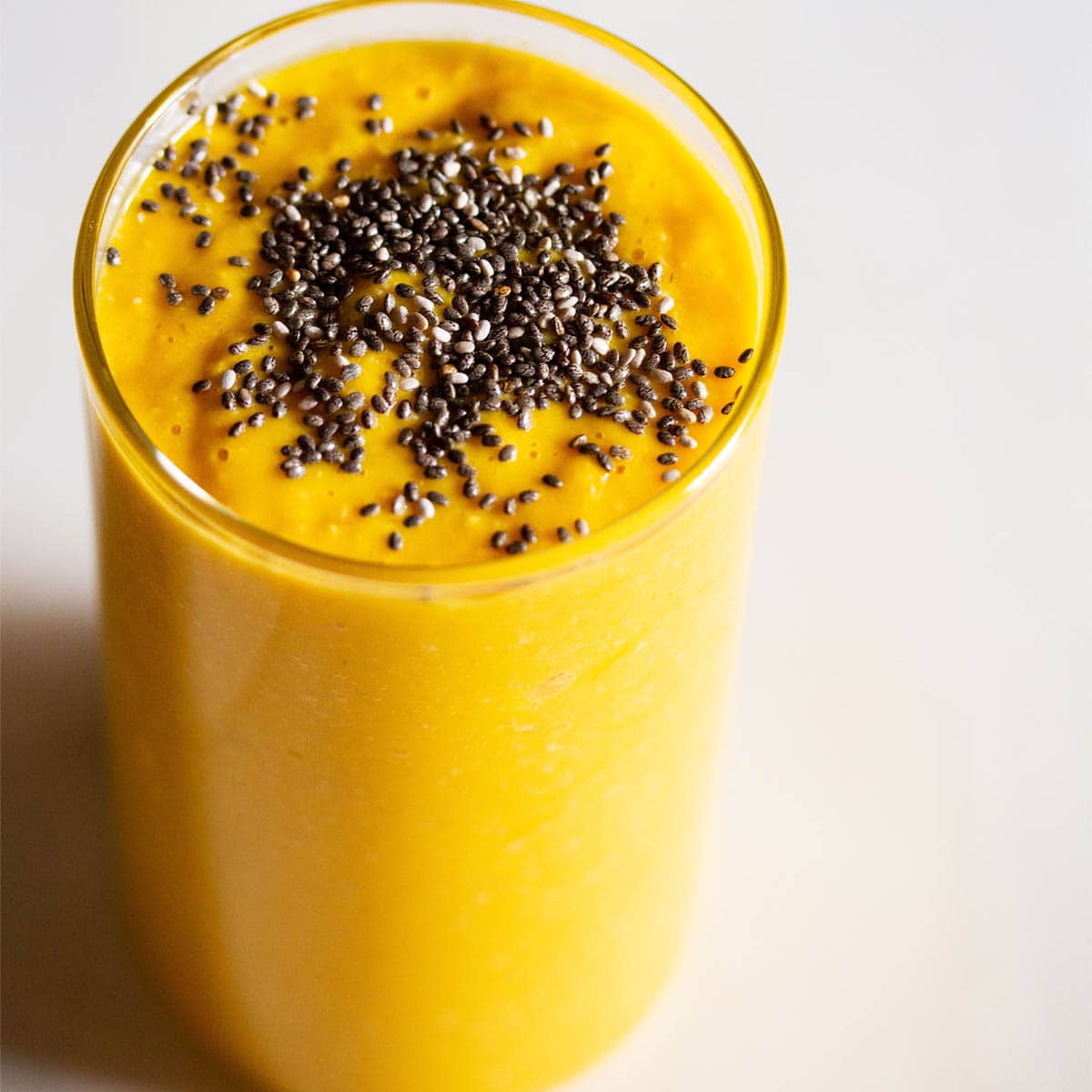mango smoothie with oats in a glass sprinkled with chia seeds