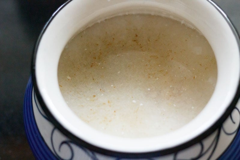 water, seasonings added to yogurt in in a white and blue designed ceramic pan