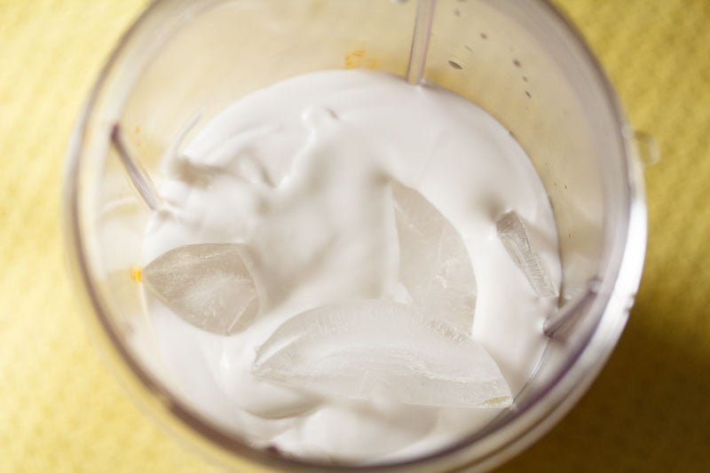 ice cubes on top of thick coconut milk in blender