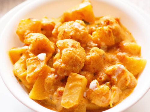 aloo gobi in a white bowl on a white board