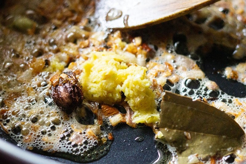 adding ginger paste to browned onions