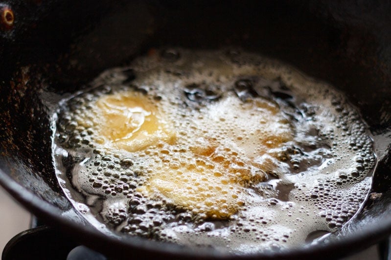 batter coated potato slice frying in hot oil