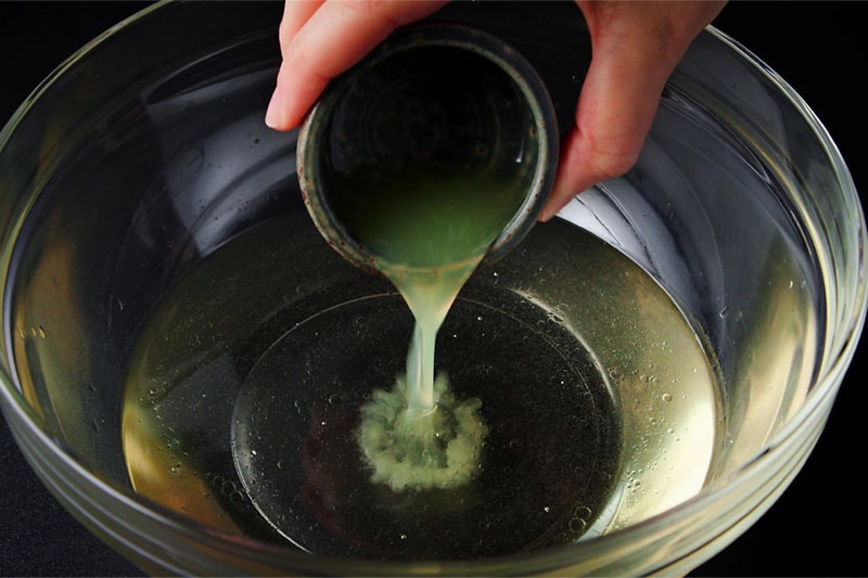 lemon juice being added to bowl with wet ingredients