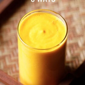 mango smoothie in a glass on a matted wooden tray with text layovers