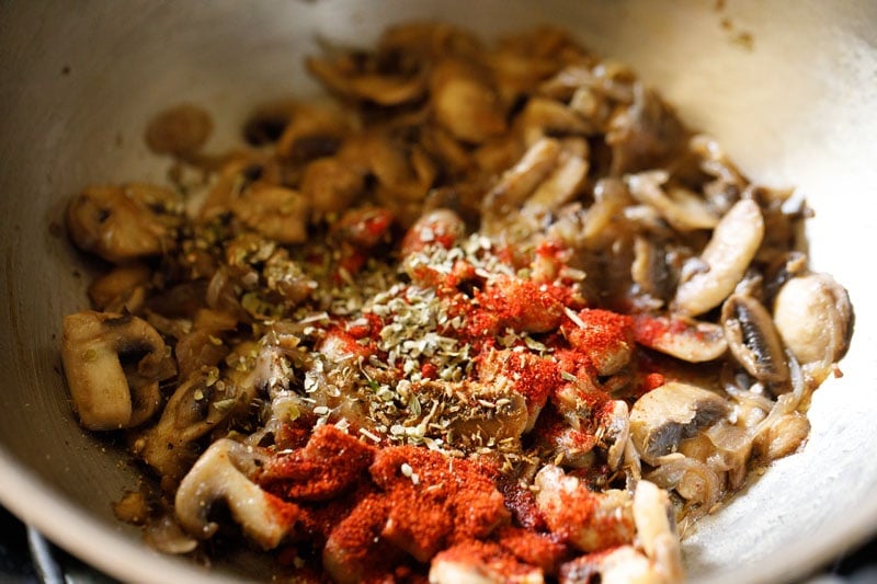 herbs and spices added to pan with mushrooms