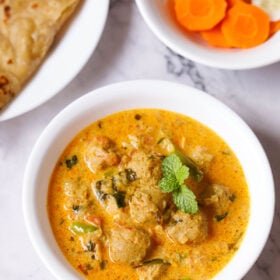 overhead shot of delicious soya chunks curry recipe in a white bowl garnished with mint