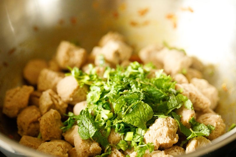 fresh herbs and soy chunks added to pot for meal maker curry