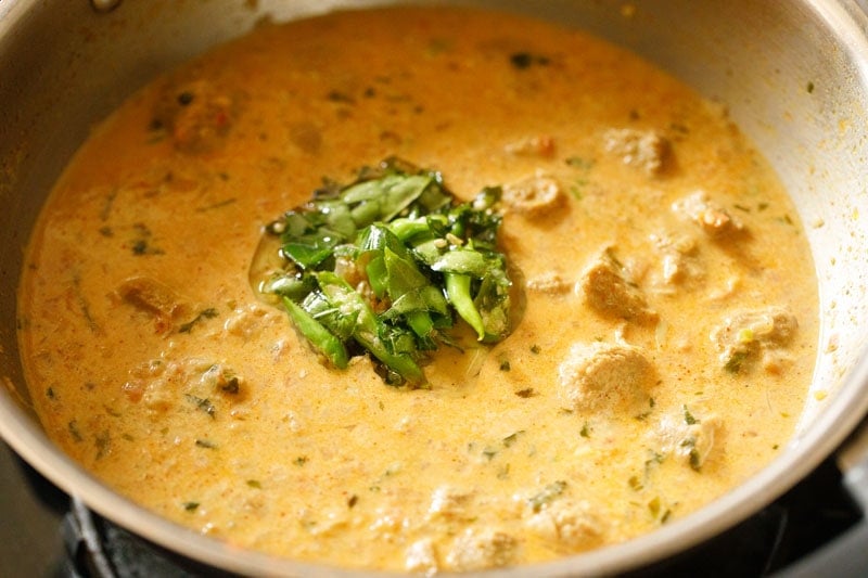 adding tempered curry leaves and chiles to soya chunks curry