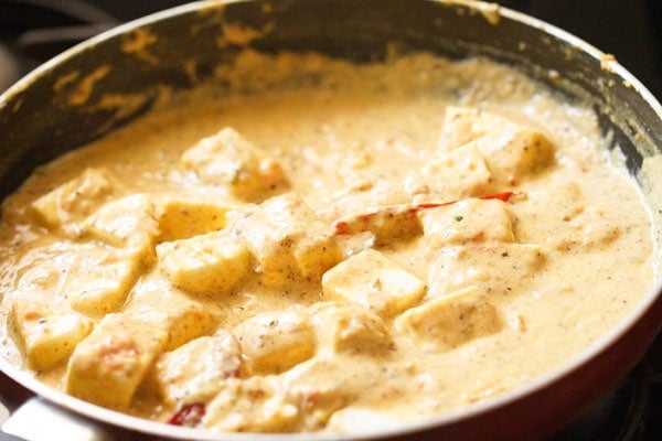 paneer stirred into achari gravy in the pan
