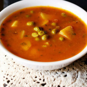 aloo matar curry served in a white bowl.