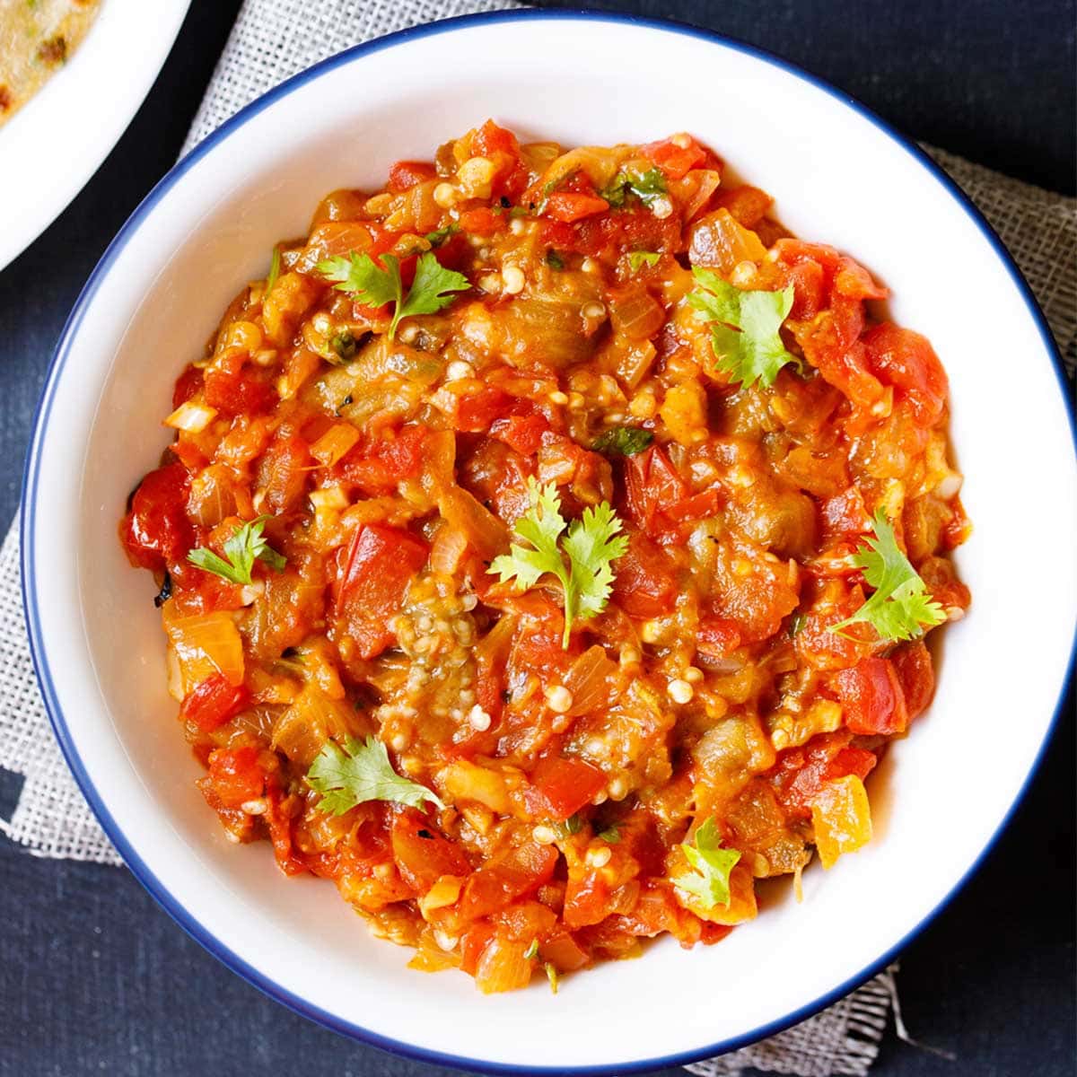 overhead shot of baingan bharta in a white bowl