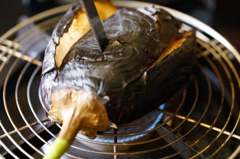 checking the roasted eggplant with a knife