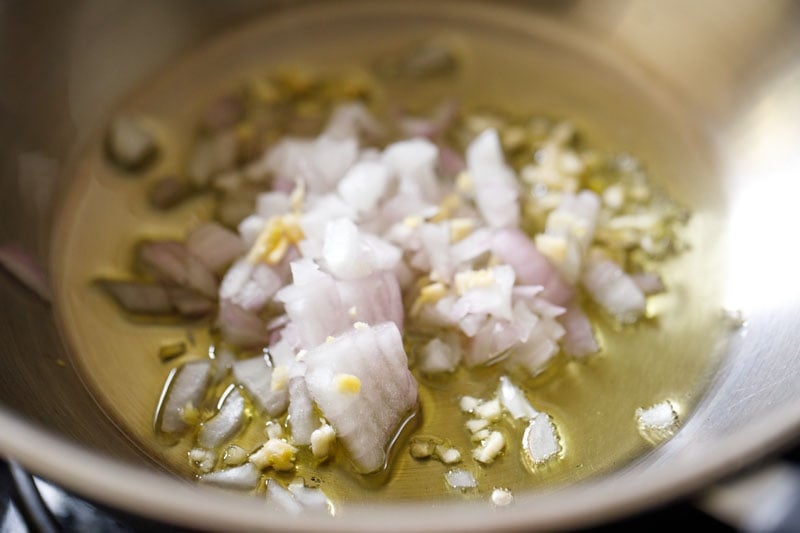 onions and garlic added to a pan with oil