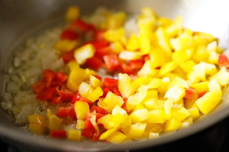 chopped red and yellow bell pepper added to the pan