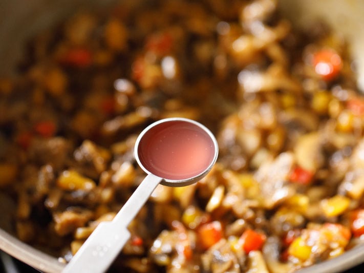 red wine vinegar being added to vegetarian burrito filling