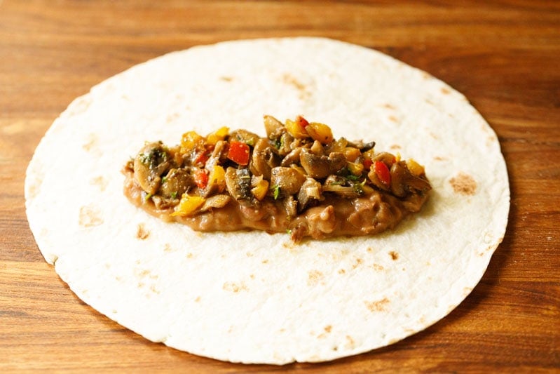 veggie burrito mix atop refried beans