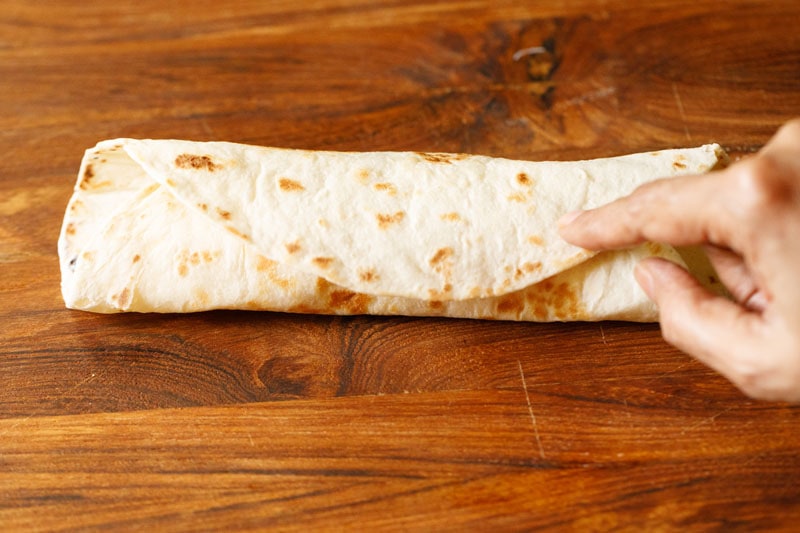 folding the other side of the tortilla to close the burrito