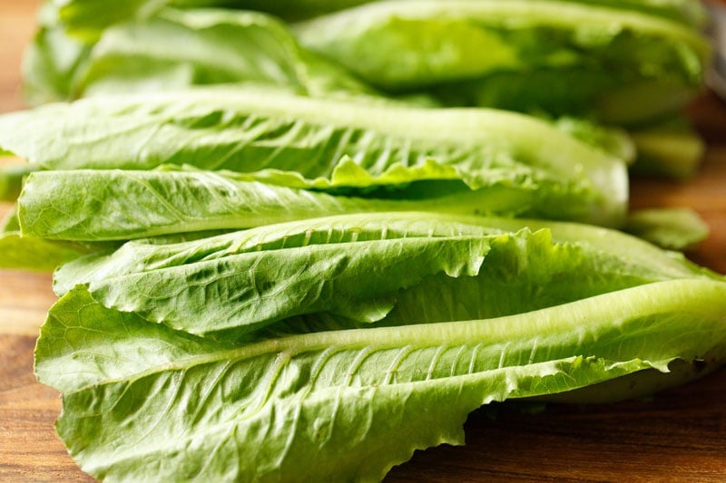 whole romaine lettuce leaves on a wooden board