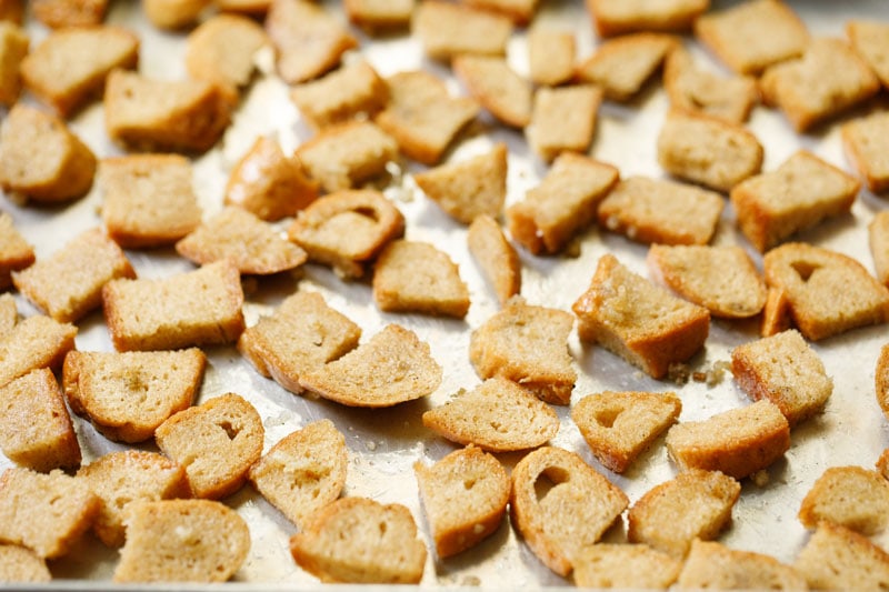 unbaked croutons spread out on a baking sheet