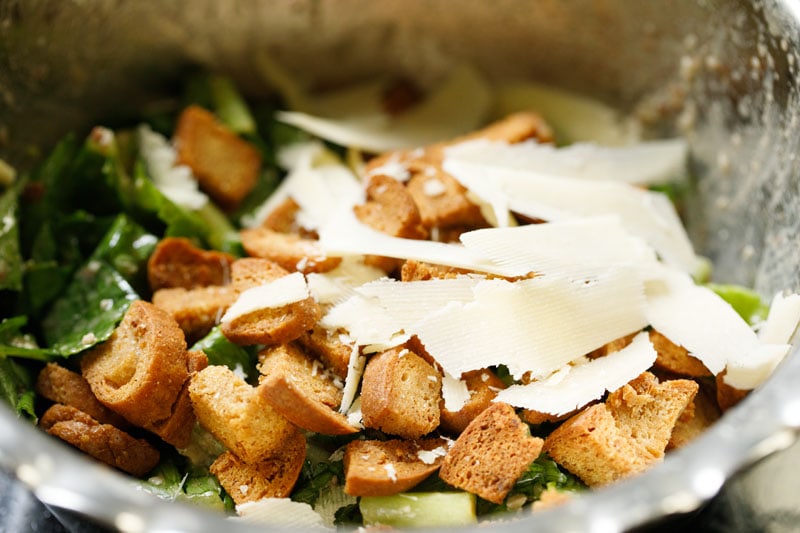 croutons and parmesan cheese shreds added to bowl