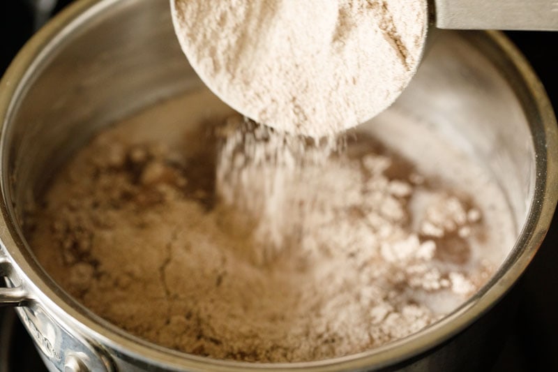 ravi flour being sprinkled over boiling mixture