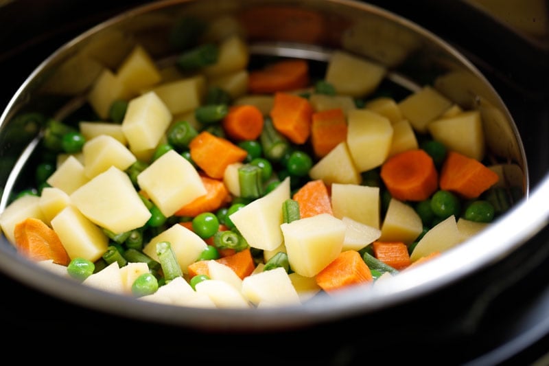 steamer pan with veggies placed on trivet in the instant pot