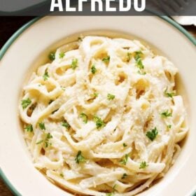 overhead shot of fettuccine alfredo sprinkled with grated parmesan and chopped parsley filled in a deep dish plate with text layovers.