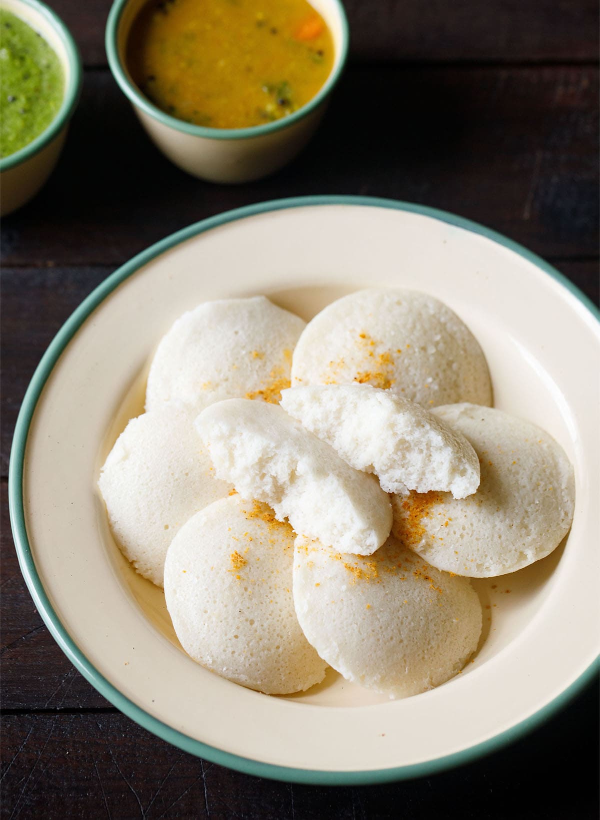 soft idli showing the fluffy texture served in a plate with sambar and chutney