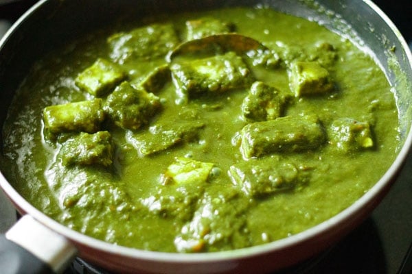 mixing cream in the palak paneer gravy