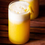 fresh pineapple juice served in two glasses and garnished with fresh pineapple pieces