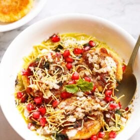 ragda patties served on a white bowl with a spoon.