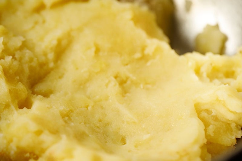 peeling and mashing the cooked potatoes