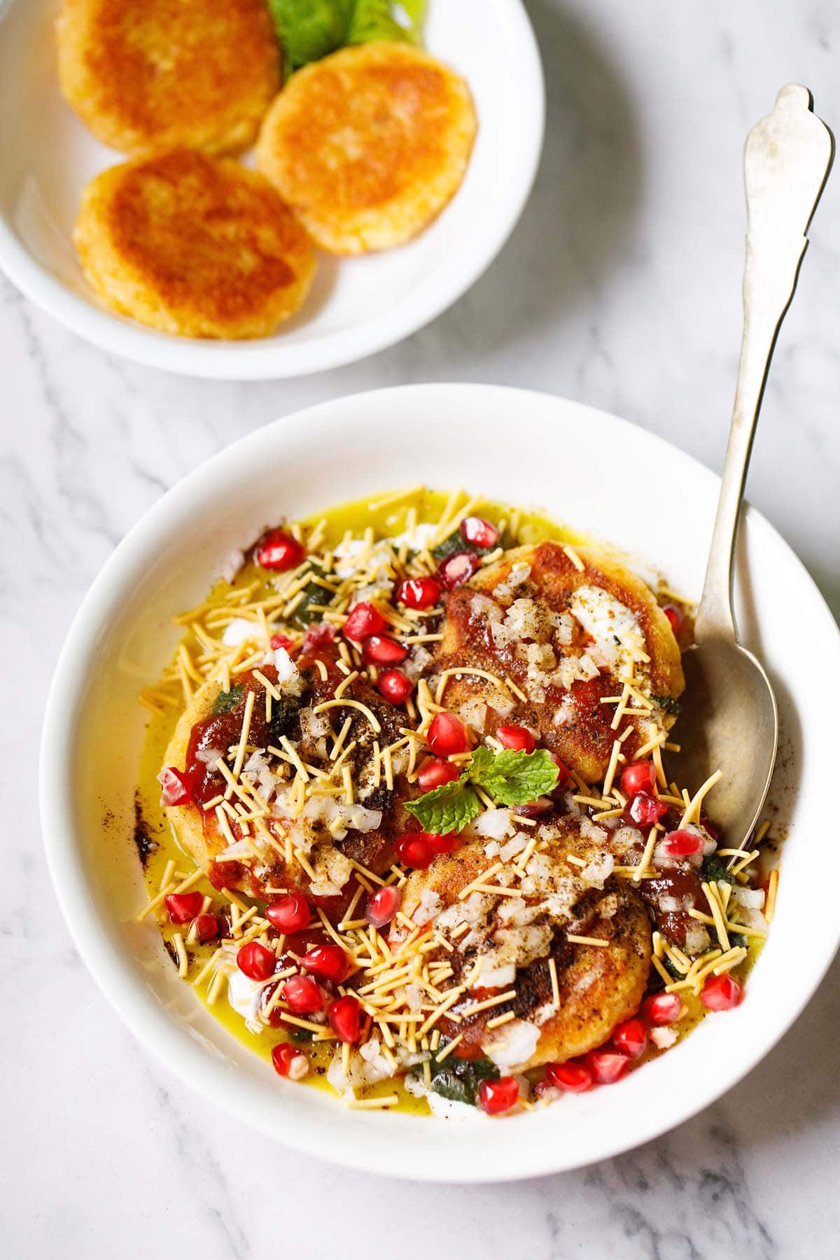 ragda patties in a white bowl with a spoon