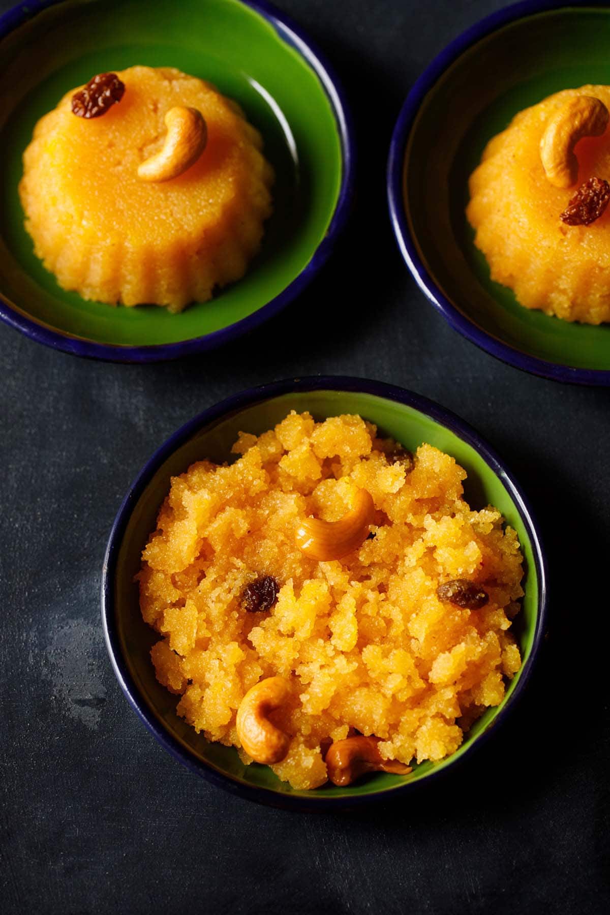 overhead shot of rava kesari recipe in dark green plate on a dark black-blue board.
