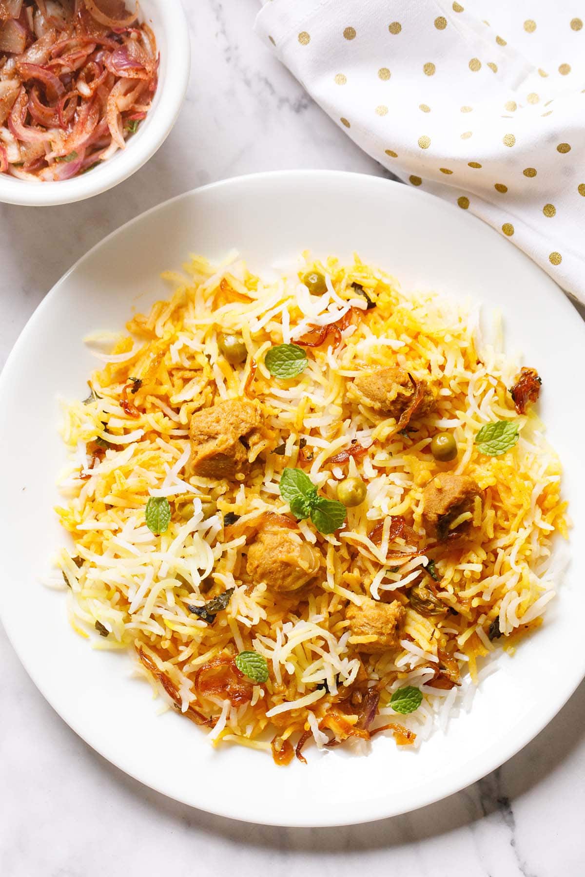 soya biryani in a white plate garnished with some mint sprigs