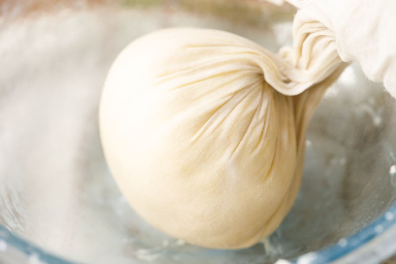 squeezing out the whey from homemade butter in cheesecloth