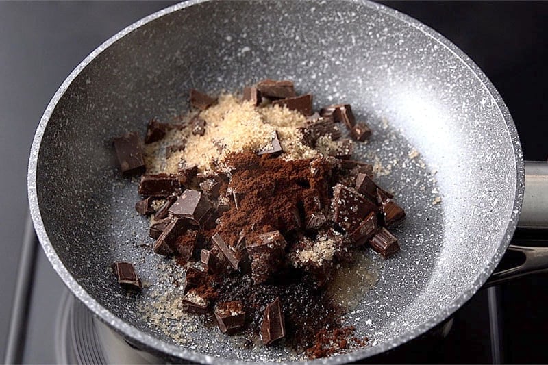 skillet with chocolate ingredients on top of saucepan
