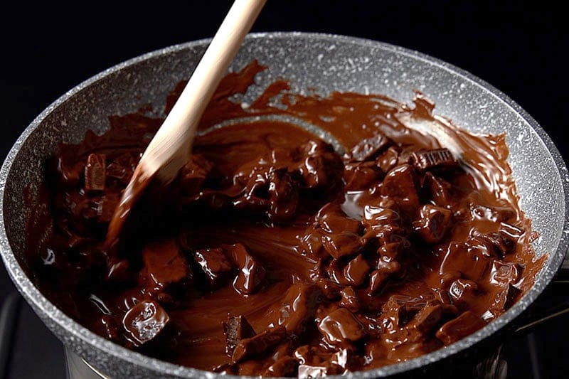 stirring the chocolate in the double boiler to help it melt evenly