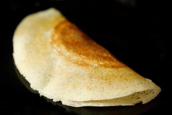 folded sada dosa on the skillet or tawa